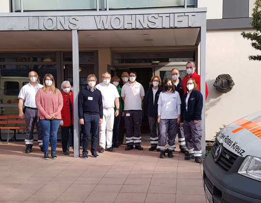 Impfteam Covid 2021 - Impfaktion Covid19 im Foyer des Lions Wohnstifts. Zu sehen sind zahlreiche Helfer und Impfpersonal sowie ein Fahrzeug des Roten Kreuzes